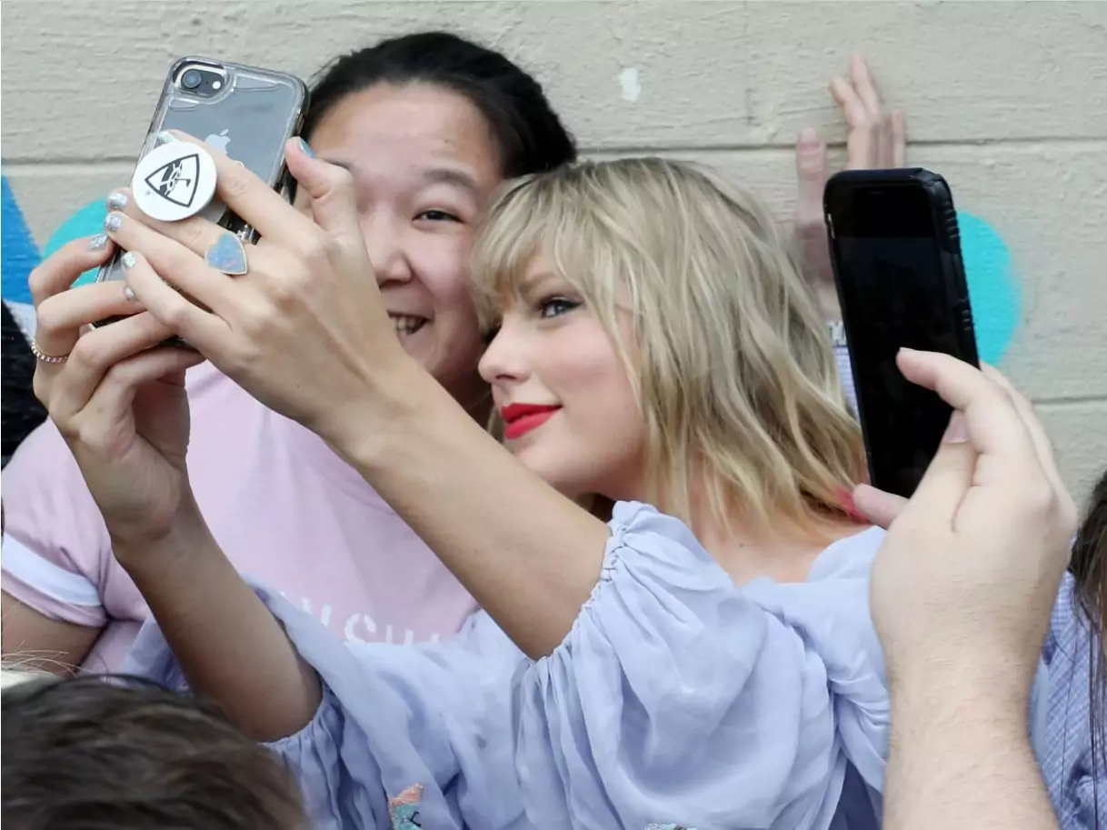 Taylor Swift, right, takes a selfie with fans in Nashville's Gulch neighborhood.
